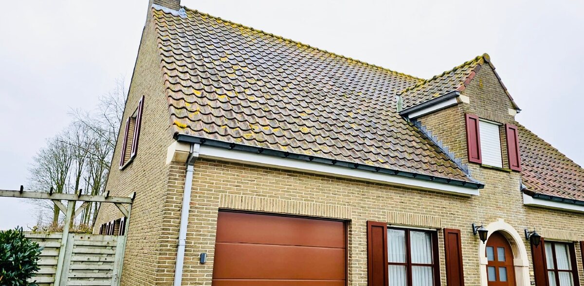 Woning met bevuild dak vóór de reiniging