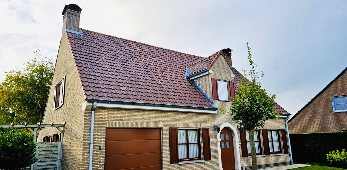Dezelfde woning met gereinigd dak na de behandeling